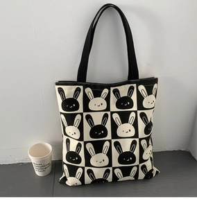 Detail of canvas tote featuring a black and white checkerboard pattern with cute rabbits