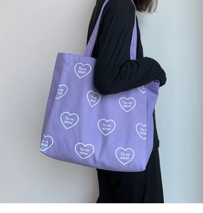Détail du sac cabas violet en toile avec imprimé cœur blanc et texte français Tu es aimé