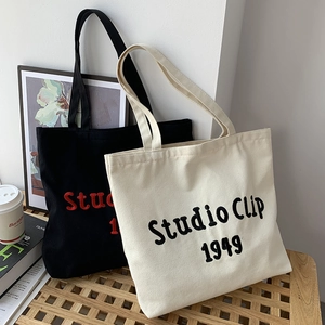 Minimalist canvas tote bags in black and white with Studio Clip 1949 embroidery lettering