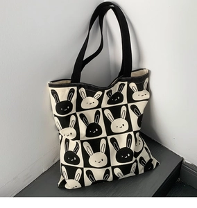 Detail shot of canvas tote featuring black and white checkerboard pattern with cute rabbits