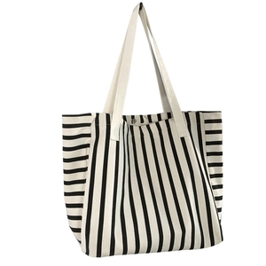 Black and white striped canvas tote bag with metal snap button and sturdy handles