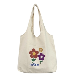 Minimalist off-white canvas tote bag featuring colorful floral patterns and wide shoulder straps