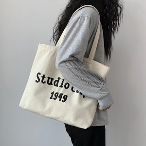 Detail of Studio 1949 canvas tote bag showing large letter print and spacious design