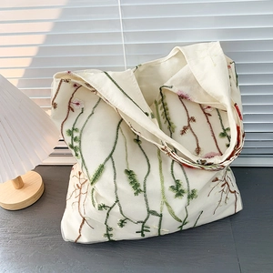 Close-up of intricate floral embroidery on mesh canvas beach bag with natural lighting