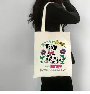 Sac fourre-tout en toile blanche avec illustration de dalmatien et fleurs porté à l'épaule