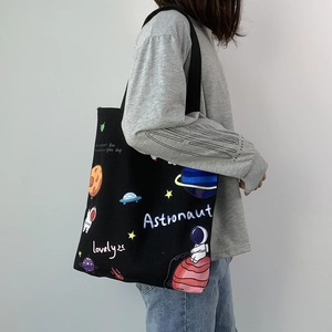 Black canvas tote bag featuring astronaut space cartoon prints for women shoulder wear