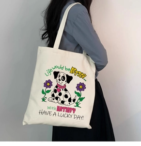 Détail d'une illustration de dalmatien sur un grand sac cabas en toile porté par un mannequin