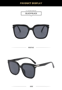 Detail view of large square black sunglasses with elegant silver metal hinges and temple
