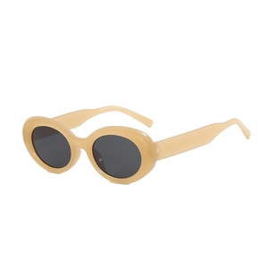 Retro oval sunglasses with a cream frame and dark lenses on a clean white background