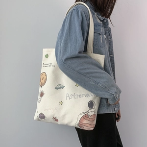 Detail view of white canvas tote bag with astronaut and space illustrations for daily use