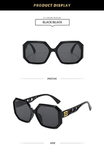 Detail view showing black oversized sunglasses with iconic gold B logo on temple