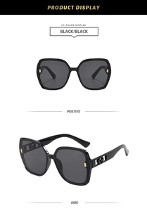 Détail de lunettes de soleil carrées oversize avec décoration de branche dorée en forme de G