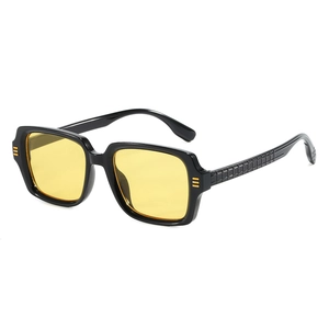 Lunettes de soleil carrées rétro avec monture noire et verres jaunes vus sous un angle de 45°