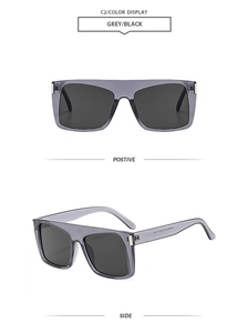 Detail view of square oversized sunglasses with grey transparent frame and black lenses