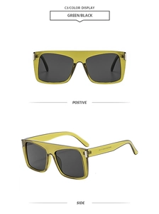 Detail of square oversized sunglasses showing green frame and dark lenses with temple markings
