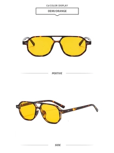 Detail view of tortoiseshell double bridge aviator sunglasses with yellow lenses
