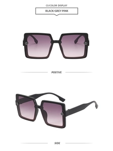 Close-up of black square sunglasses with gradient pink lenses and metal G logo