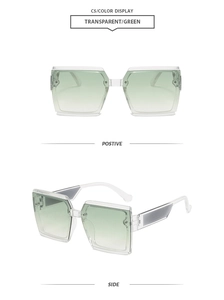 Detail of square oversized sunglasses with transparent frames and green gradient lenses