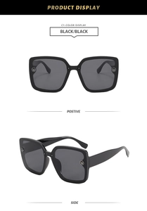 Detail view of square oversized black sunglasses with silver W logo on temples