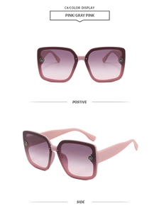 Detail of pink square sunglasses featuring gradient lenses and metal logo on frame temple