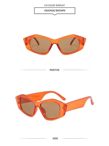 Detail view of stylish orange oversized geometric sunglasses with brown lenses