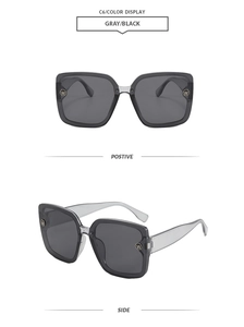 Detail view of square oversized sunglasses with gray translucent frames and W logo