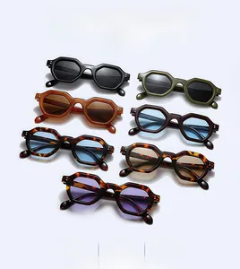 Flat lay of small polygon sunglasses in various colors with thick frames and rivets