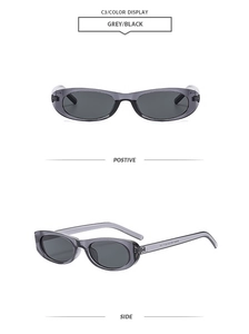 Detail view of oval semi-transparent grey frame sunglasses with dark black lenses