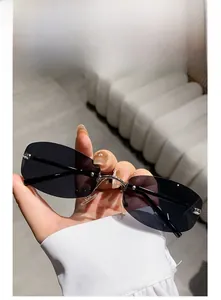 Detail of rimless rectangle sunglasses with dark gray lenses and slim metal bridge
