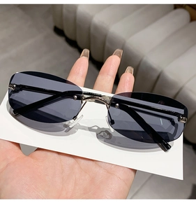 Detail of rimless oval sunglasses with grey lenses and silver metal temple arms