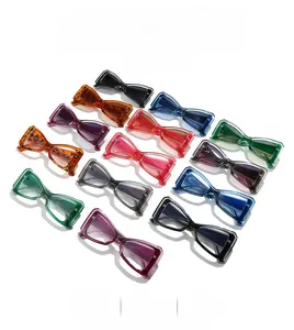Flat lay of multiple colorful cat eye sunglasses in a grid pattern on a white background