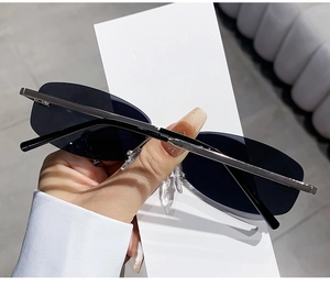 Detail of rimless oval sunglasses with black lenses and silver metal temples