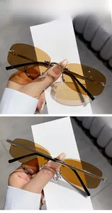 Detail of rimless gold metal sunglasses with brown lenses and sleek black temple tips