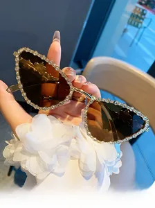 Détails de lunettes œil-de-chat avec monture en métal doré et strass brillants étincelants