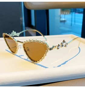 Gros plan de lunettes œil-de-chat dorées avec bords en strass et cristaux en forme d'étoile