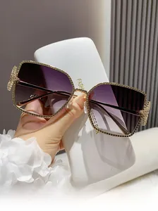 Detail of square gold metal sunglasses frame with beaded edges and star decoration