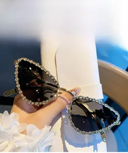 Gros plan de lunettes de soleil œil-de-chat avec bords en strass et branches dorées