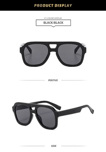 Detail view of black aviator sunglasses with silver metal double bridge accents and dark lenses