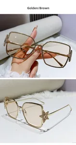 Detail of gold metal square sunglasses featuring star-shaped rhinestone accents and tea lenses