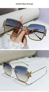 Detail of square gold metal sunglasses with beaded edges and star decor on temples