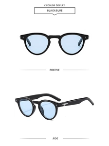 Detail view of round black sunglasses with blue lenses and silver star metal accents