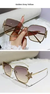 Detail of golden metal sunglasses frame with star-shaped rhinestones and gradient lenses