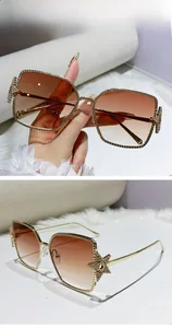 Detail of gold metal frame sunglasses with star accents and gradient brown lenses