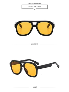 Detail of vintage aviator sunglasses with black frames and vibrant orange lenses