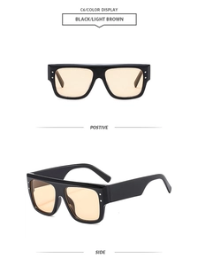 Detail of square oversized sunglasses showing metal rivets and light brown lenses
