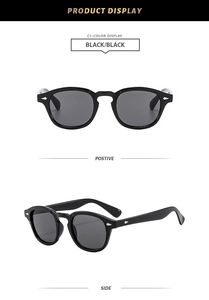 Close-up of retro round black sunglasses with silver rivet accents and grey lenses
