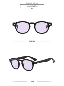 Close-up of vintage round sunglasses with black frames, purple lenses, and silver arrow rivets