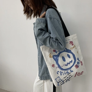 Detailed close-up of a white canvas tote bag with colorful graffiti and smiley face art