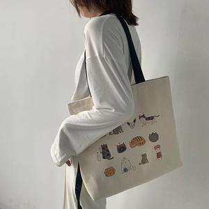 Vue détaillée d'un grand sac cabas en toile avec des illustrations de chats colorés porté