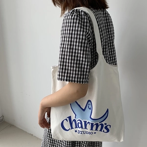 Detail of white canvas tote with blue Charm's Studio print and cartoon ghost